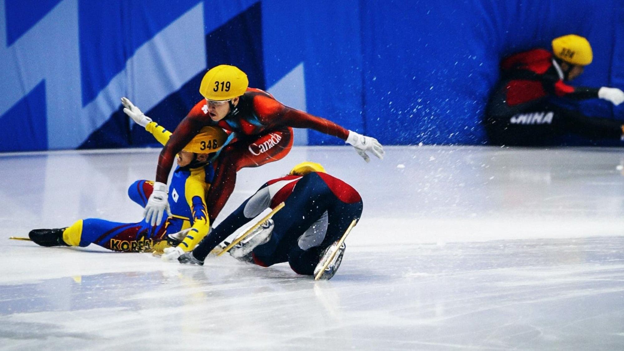Image des 4 patineurs à terre dans le dernier virage de la finale de 1000m aux JO de Salt Lake City en 2002
