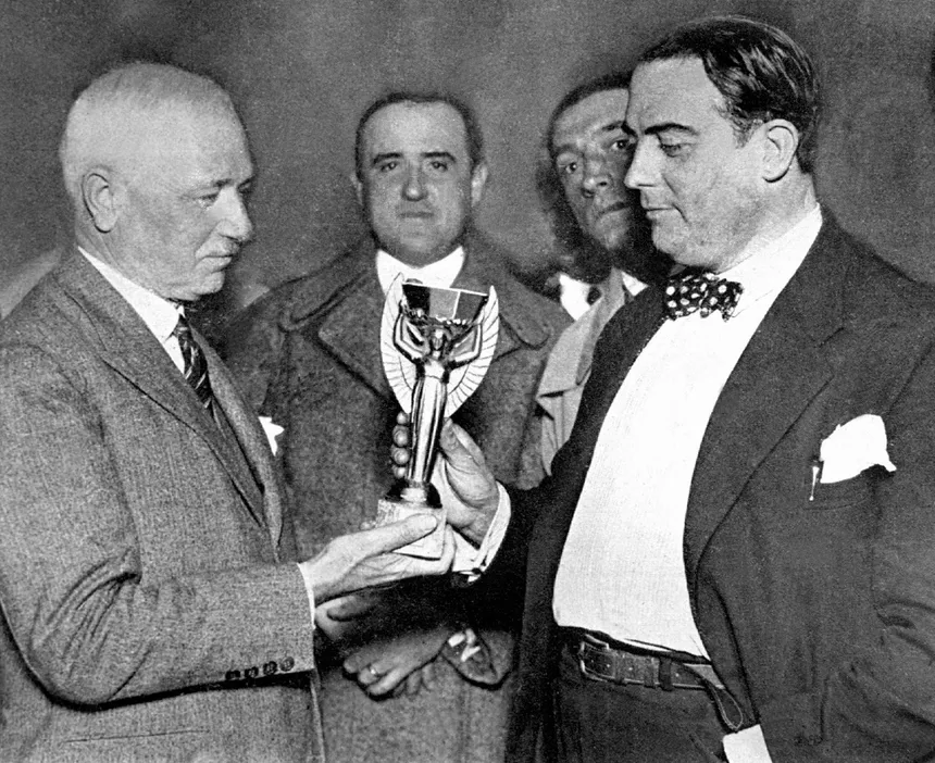 Jules Rimet (à gauche) remettant le trophée au président de la Fédération Uruguayenne de Football (à droite)